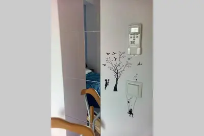 a room with a phone and a tree and birds on the wall at Teros apartment in Athens