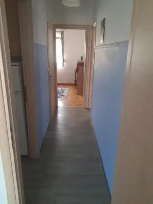 a hallway leading into a room with a white refrigerator at Teros apartment in Athens