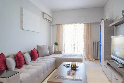 a living room with a large couch and a television at Spacious and Luxurious Apart Athens Center by MPS in Athens