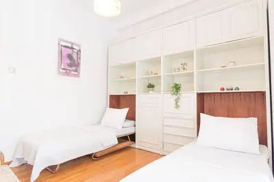 two beds in a room with white cabinets at Spacious and Luxurious Apart Athens Center by MPS in Athens
