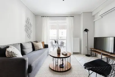 a living room with a couch and a tv at Ideal 1 BR Apartment in Petralona by UPSTREET in Athens