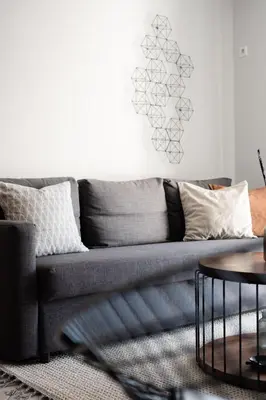 a living room with a gray couch and a table at Ideal 1 BR Apartment in Petralona by UPSTREET in Athens