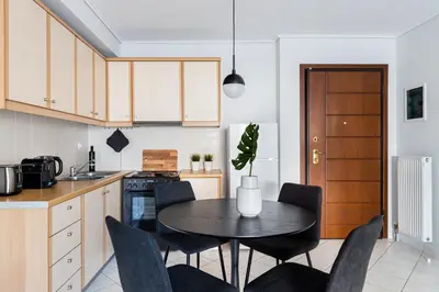 a kitchen with a table and chairs in a kitchen at Ideal 1 BR Apartment in Petralona by UPSTREET in Athens