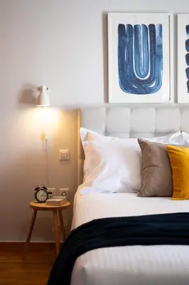 a bedroom with a bed and a table with a clock at Ideal 1 BR Apartment in Petralona by UPSTREET in Athens