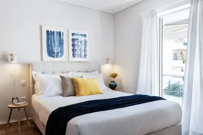 a white bedroom with a large bed and a window at Ideal 1 BR Apartment in Petralona by UPSTREET in Athens