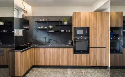 a kitchen with wooden cabinets and a black appliance at Luxury Apt near the Beach Athens Riviera by Olon in Athens
