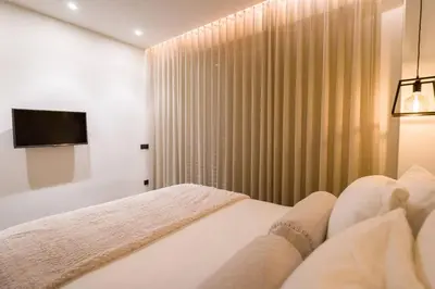 a bedroom with a bed and a window with a television at Luxury Apt near the Beach Athens Riviera by Olon in Athens