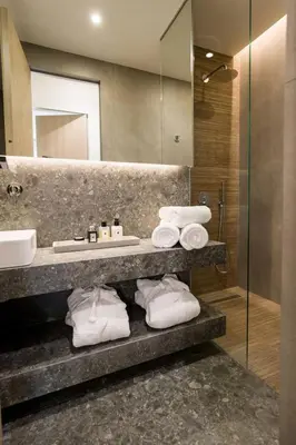 a bathroom with a sink and a mirror and towels at Luxury Apt near the Beach Athens Riviera by Olon in Athens