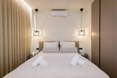a bedroom with a large white bed with two pillows at Luxury Apt near the Beach Athens Riviera by Olon in Athens