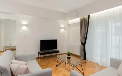a living room with a couch and a tv at Kolonaki Luxury Residence in Athens
