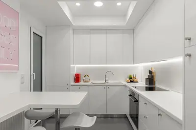 a white kitchen with white cabinets and a sink at Kolonaki Luxury Residence in Athens