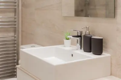 a bathroom with a white sink with two bottles on it at Kolonaki Luxury Residence in Athens
