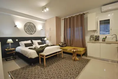 a bedroom with a large bed and a kitchen at Window to...Acropolis! in Athens