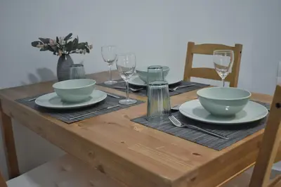 a wooden table with plates and bowls and wine glasses at Window to...Acropolis! in Athens