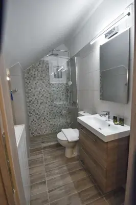 a bathroom with a sink and a toilet and a mirror at Window to...Acropolis! in Athens