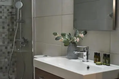 a bathroom sink with a vase of flowers on it at Window to...Acropolis! in Athens
