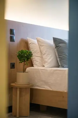 a bed with pillows and a potted plant on a table at Metis Urbane Living Spaces in Athens