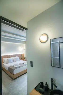 a bedroom with a bed with a mirror and a sink at Metis Urbane Living Spaces in Athens
