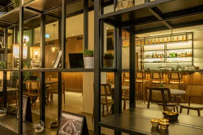 a restaurant with glass windows and tables and chairs at Metis Urbane Living Spaces in Athens