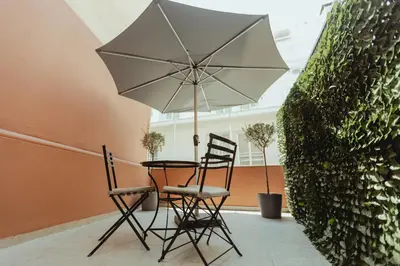 a table with two chairs and an umbrella at Metis Urbane Living Spaces in Athens