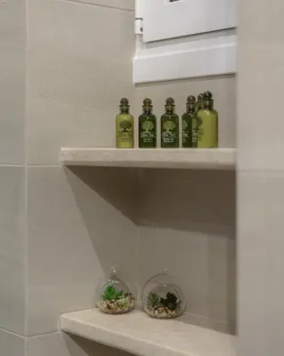 a row of bottles sitting on a shelf in a bathroom at Acropolis Deluxe Apartment in Athens