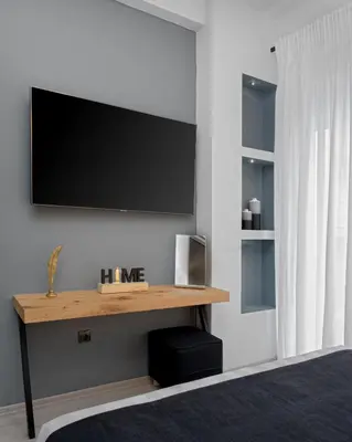 a living room with a television on a wall at Acropolis Deluxe Apartment in Athens
