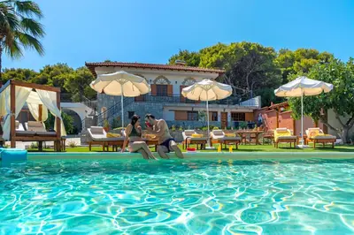 two people in a swimming pool at a resort at Villa Artemida Vravrona in Vravrona