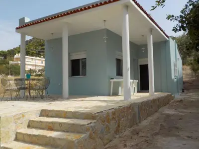 a small blue house with a table and chairs at Casa Aqua Marina in Aghia Marina