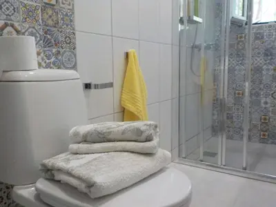 a pile of towels sitting on top of a toilet in a bathroom at Casa Aqua Marina in Aghia Marina