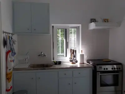 a white kitchen with a sink and a stove at Casa Aqua Marina in Aghia Marina