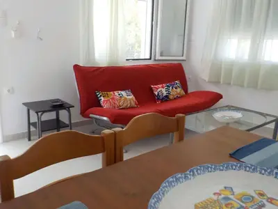 a living room with a red couch and a glass table at Casa Aqua Marina in Aghia Marina