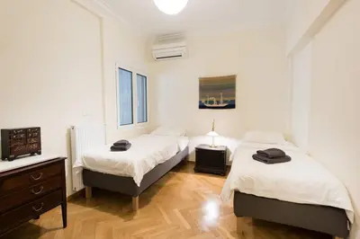a bedroom with two beds and a television in it at Klokkaris Stays Athens in Athens
