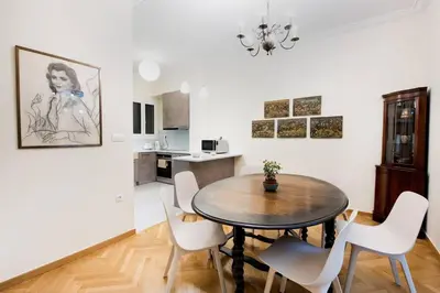 a dining room with a table and white chairs at Klokkaris Stays Athens in Athens