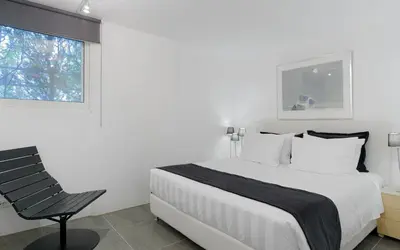a bedroom with a bed and a chair and a window at Luxurious Beachfront Villa Maira in Aghia Marina