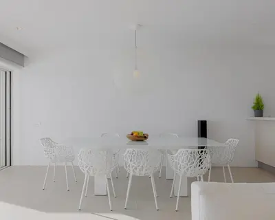 a white dining room with a white table and chairs at Luxurious Beachfront Villa Maira in Aghia Marina