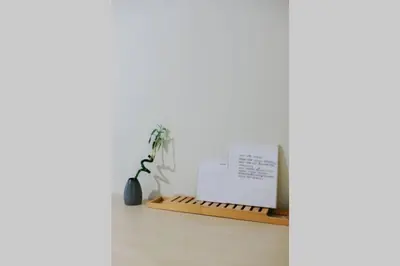 a white room with a plant and a wooden shelf at Newly Renovated Athenian Apt with Balcony in Athens