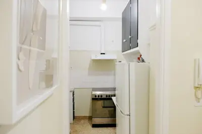 a white kitchen with a refrigerator and a stove at Newly Renovated Athenian Apt with Balcony in Athens