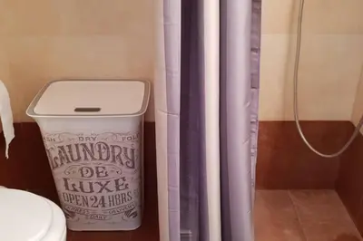a bathroom with a shower curtain and a trash can at CLOVER 3m to panormou metro station in Athens
