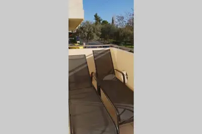 a balcony with two chairs on top of a building at CLOVER 3m to panormou metro station in Athens