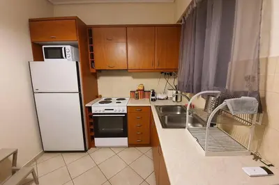 a small kitchen with a white refrigerator and a sink at CLOVER 3m to panormou metro station in Athens