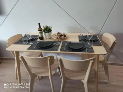 a table with chairs and a table with wine glasses at VARKIZA VIEW APARTMENT in Varkiza