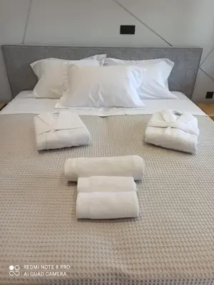 a bed with white towels on it with at VARKIZA VIEW APARTMENT in Varkiza