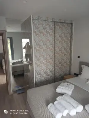 a bedroom with a bed with towels and a mirror at VARKIZA VIEW APARTMENT in Varkiza