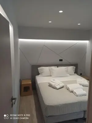 a bedroom with a bed with two towels on it at VARKIZA VIEW APARTMENT in Varkiza