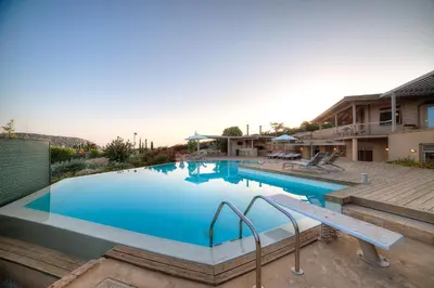 a large swimming pool with blue water in a yard at LYCIPONON Villa in Anavissos