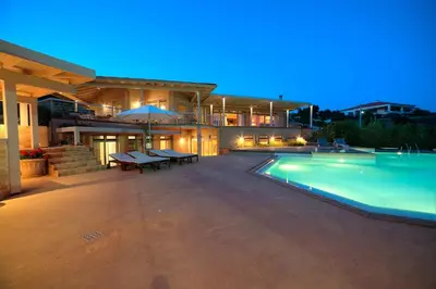 a large house with a swimming pool in front of it at LYCIPONON Villa in Anavissos