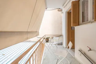 a room with a balcony with a chair and a table at Private Rooms Athens - Shared Bathroom in Athens