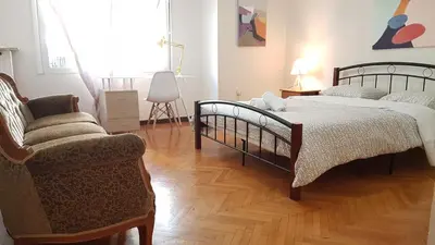 a bedroom with two beds and a chair at Teal Apartment - Athens Center, 4 BD, 2 BATH in Athens
