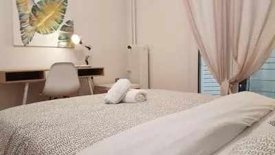 a white bed with a stuffed animal on top of it at Teal Apartment - Athens Center, 4 BD, 2 BATH in Athens