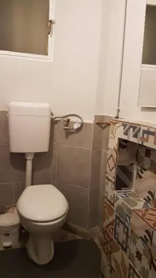 a bathroom with a white toilet in a room at Teal Apartment - Athens Center, 4 BD, 2 BATH in Athens